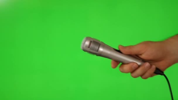 Hand hold a microphone on green screen — Stock Video