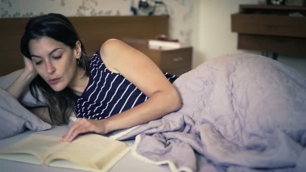 Frau genießt Lesen im Bett — Stockvideo