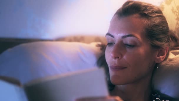 Kobieta w łóżku czytając książkę — Wideo stockowe