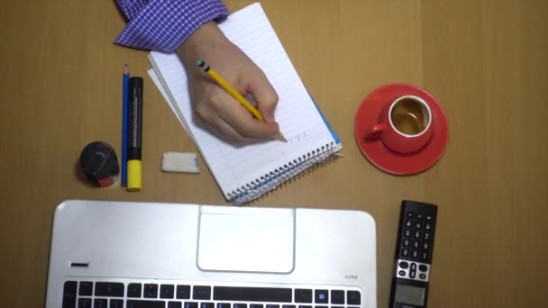 Top view of man work on desktop with laptop and notebook — Stock Video