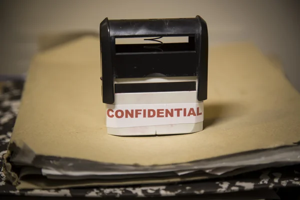 Confidential stamp on a big folder of paperwork — Stock Photo, Image