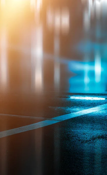 Dark street, wet asphalt, reflections of rays in the water. Abstract dark blue background, smoke, smog. Empty dark scene, neon light, spotlights. Concrete floor