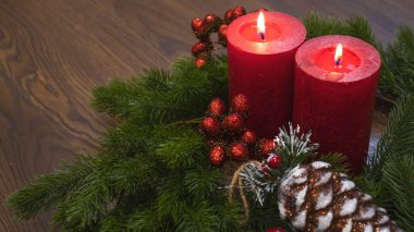 Köknar dallı kırmızı mumlar ve oyuncak çam kozalağı. Karanlık Noel ve yeni yıl geçmişi. Kırmızı mumlar, yeşil ladin dalları, kırmızı çilekler..