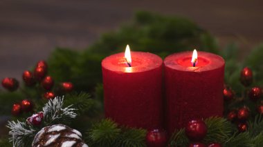 Köknar dallı kırmızı mumlar ve oyuncak çam kozalağı. Karanlık Noel ve yeni yıl geçmişi. Kırmızı mumlar, yeşil ladin dalları, kırmızı çilekler..