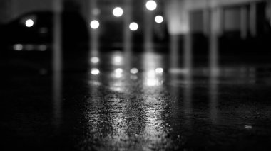 Karanlık sokak, siyah arka plan, ıslak asfaltta ışık parlaması. Işınlar ve çizgiler, duman. Karanlık şehir sokağı.