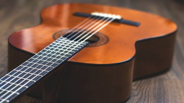 Ahşap bir arka planda tahta gitar, yakın plan, teller. Müzik retro enstrümanı. 