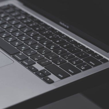 Macbook Apple M1 ve iPhone 12 Pro Max ile karanlık özne minimalist arka planı. Siyah parlak bir masanın üzerinde sade kahve olan beyaz bir fincan. Belarus Gomel - 09.03.2021 