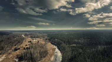 Düzlükleri ve ormanı, nehri, üst manzarası, fantezi manzarası, koyu yeşil gökyüzü, sarı tarlası olan manzara. Doğal güzel koyu arkaplan. 