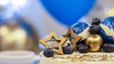 Arka planda balonlar ve ışıltılarla el yapımı bir doğum günü pastası. Cheesecake keki, mavi ve altın aksanlı. Kartpostal, tatil, doğum günü, yıldönümü, 18 yıl. 