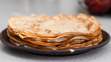 Sıcak bir ev mutfağında ince krep yapma süreci. Kızartma tavasında ve toprak kabında krep. İnce krepler yakın plan. Açık mutfak iç mimarisi. 