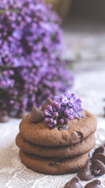 Dekoratif kompozisyon. Mutfağın iç tarafında bir demet leylak var. Bir fincan çay ve çikolatalı kek. Vazoda bir buket leylak. İç kısımlarında leylaklar olan bahar çiçekleri.. 