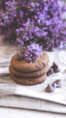 Dekoratif kompozisyon. Mutfağın iç tarafında bir demet leylak var. Bir fincan çay ve çikolatalı kek. Vazoda bir buket leylak. İç kısımlarında leylaklar olan bahar çiçekleri.. 