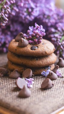 Dekoratif kompozisyon. Mutfağın iç tarafında bir demet leylak var. Bir fincan çay ve çikolatalı kek. Vazoda bir buket leylak. İç kısımlarında leylaklar olan bahar çiçekleri.. 