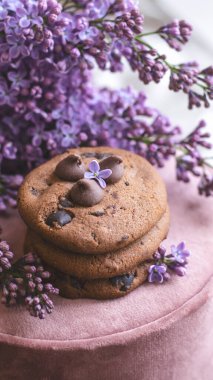 Dekoratif kompozisyon. Mutfağın iç tarafında bir demet leylak var. Bir fincan çay ve çikolatalı kek. Vazoda bir buket leylak. İç kısımlarında leylaklar olan bahar çiçekleri.. 