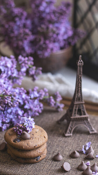 Декоративная композиция с букетом сирени в светлом интерьере кухни. Чашка чая и шоколадный торт. Букет сирени в вазе. Весенний цветочный фон с сиренью в интерьере. 