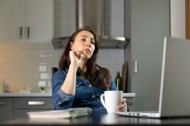 Mutfaktaki ofis telefonunda ihtiyatlı kadınlar. Evden çalışıyorum. Yeni normal kavram.