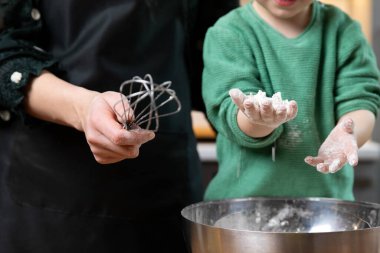 Küçük çocuk evdeki sıcak bir mutfakta unla oynuyor. Mutlu aile ve hobi kavramı.