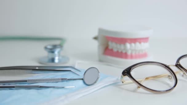 歯医者のオフィスのテーブルの上の歯医者のモデルとプロの歯医者のツール — ストック動画