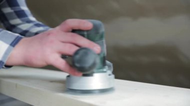 Marangozluk. Ahşap zımparalama. Orbital zımpara makinesi ahşap işçiliği için. Doğal bir ışıkta