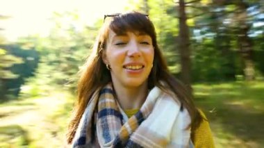 Genç, mutlu esmer, uzun saçlı. Parlak güneş ışığında ormanda dönüyor.