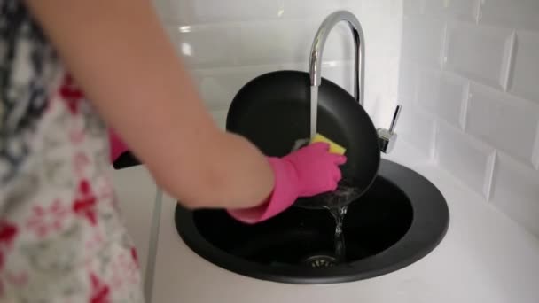 수돗물 밑에서 프라이팬을 싱크대에서 노란색 스폰지 손으로 세탁하는 손으로 빨래하는 — 비디오