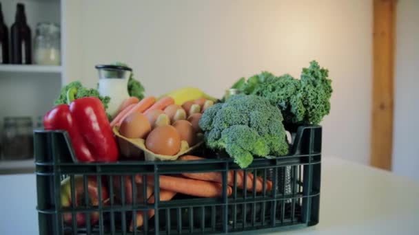 フードデリバリーサービス 灰色の背景に食料品箱を持つ女性 — ストック動画