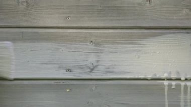 Adamın eli ahşap evin dış duvarını boya fırça ve ahşap koruyucu renkle.