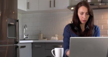 Mutfaktaki ofis telefonunda ihtiyatlı kadınlar. Evden çalışıyorum. Yeni normal kavram.