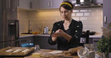 Güzel kadınlar evdeki rahat bir mutfakta ahşap bir masanın üzerinde turta hazırlıyorlar. Ev işleri ve hobiler kavramı.