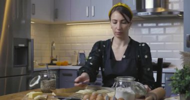 Güzel kadınlar evdeki rahat bir mutfakta ahşap bir masanın üzerinde turta hazırlıyorlar. Ev işleri ve hobiler kavramı.