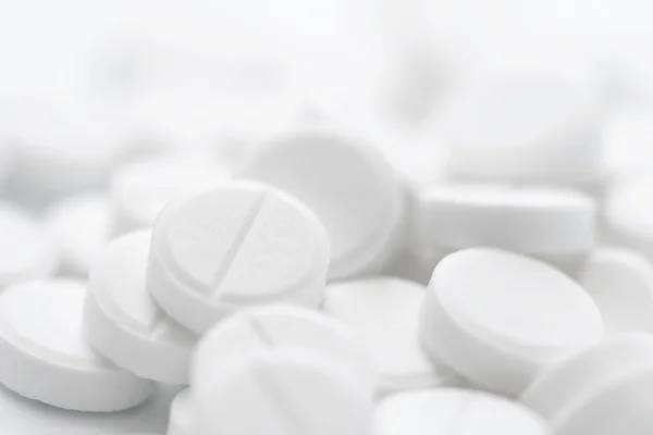 Stapel weißer Pillen in Großaufnahme auf weißem Hintergrund — Stockfoto