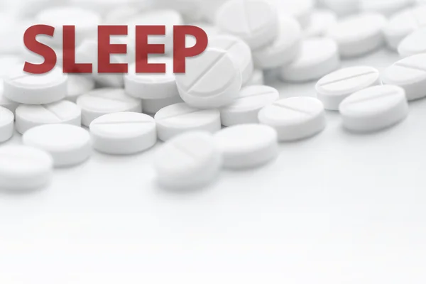 Stapel weißer Pillen in Nahaufnahme auf weißem Hintergrund mit Text sle — Stockfoto
