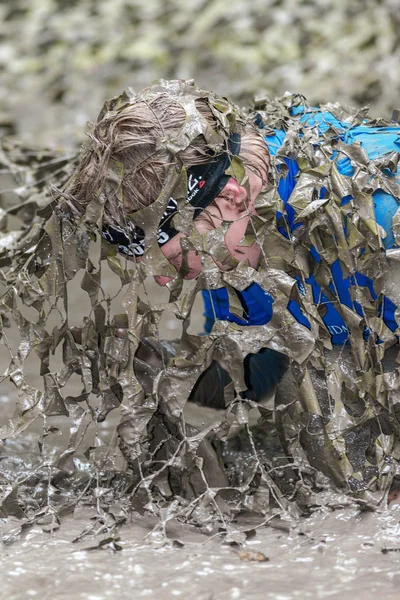 Tough Viking engel kuryalarında çamurlu ağ tuzağının altında sürünerek — Stok fotoğraf