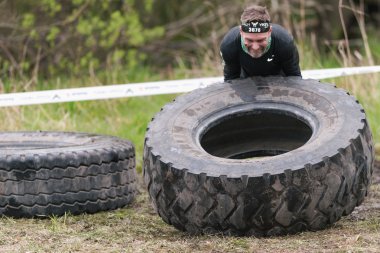 Stockh etrafında Tough Viking engel kursunda lastik çevirme adam
