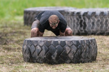 Stockh etrafında Tough Viking engel kursunda lastik çevirme adam