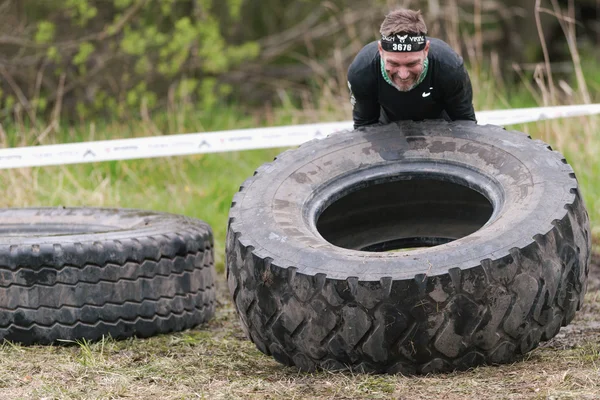Man flipping tires at Tough Viking obstacle course around Stockh — Stock Photo, Image