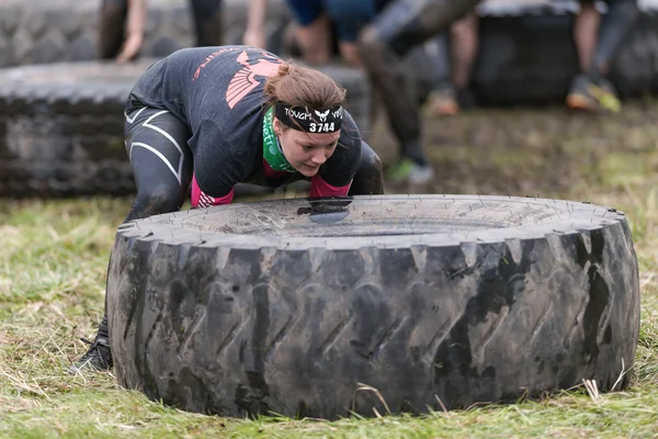 Woman flipping tires at Tough Viking obstacle course around Stoc — Stock Photo, Image