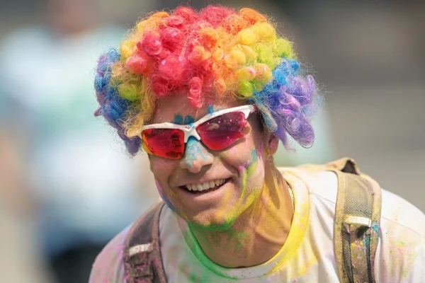 Homem usando uma peruca arco-íris entre as estações de cor em Color Ru — Fotografia de Stock