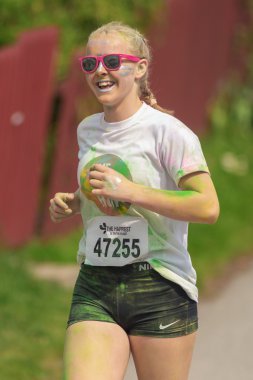 Color Run Tropi renk istasyonları arasında Mutlu gülümseyen kız