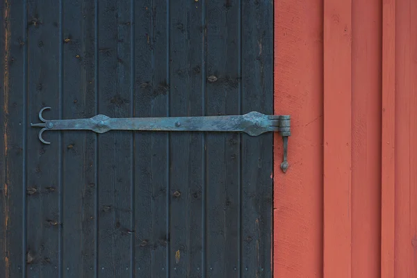 Ornamented hinge on a black barn door — Stock Photo, Image