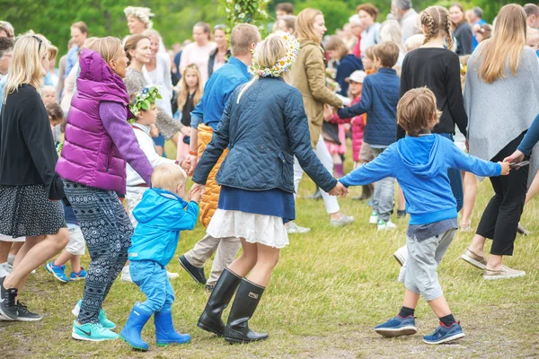 People celebrating midsummer with dance around the maypole — Stock Photo, Image