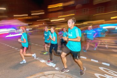 Stockholm'deki Gece Yarısı koşusunda renkli hareket bulanıklığı içinde koşucular