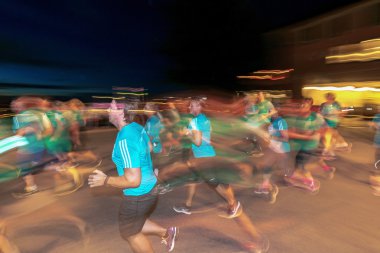 Stockholm'deki Gece Yarısı koşusunda renkli hareket bulanıklığı içinde koşucular