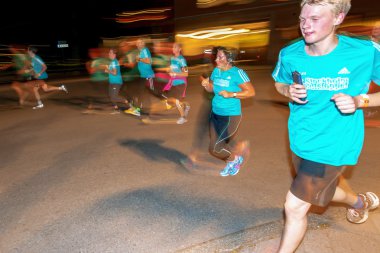 Stockholm'deki Gece Yarısı koşusunda renkli hareket bulanıklığı içinde koşucular