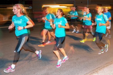 Stockholm'deki Gece Yarısı koşusunda renkli hareket bulanıklığı içinde koşucular