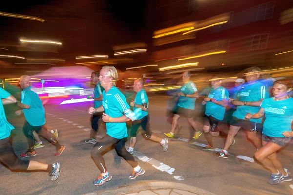 Läufer in bunter Bewegung verschwimmen beim Mitternachtslauf in Stockholm — Stockfoto