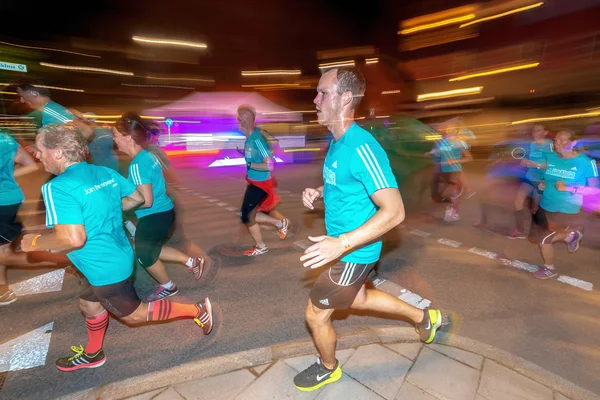 Бегуны в цветных движениях размываются на забеге "Полночь" в Стокгольме — стоковое фото