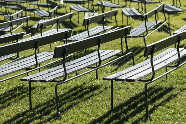 Abstrakcyjna widok zielony ławki na zielonej trawie — Zdjęcie stockowe