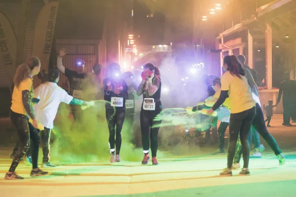 Kleurrijke gelukkige mensen op gele station in de Color Run nacht E — Stockfoto