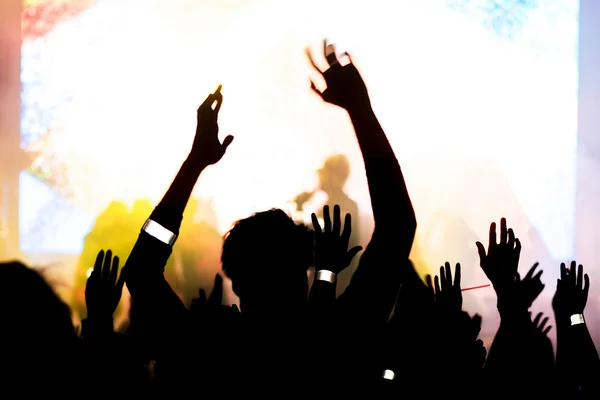 Hands and arms silhouette of happy people infront of the stage a — Stock Photo, Image